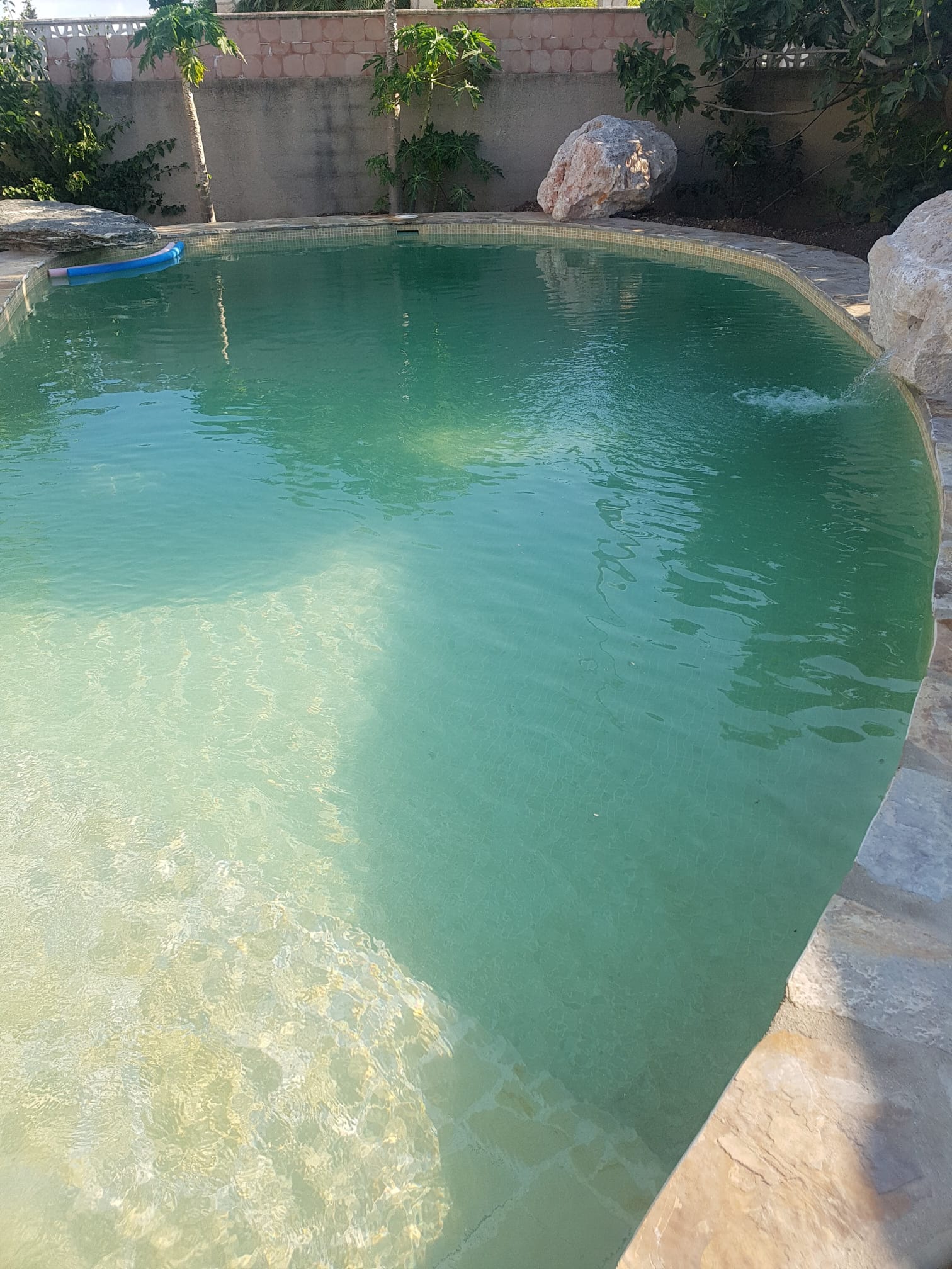 Pool water closeup with natural stone